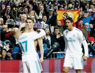  ??  ?? Real Madrid’s forward Cristiano Ronaldo (2L) celebrates with Lucas Vazquez and Raphael Varane after scoring during the UEFA Champions League quarter-final second leg match at the Santiago Bernabeu stadium yesterday PHOTO: AFP