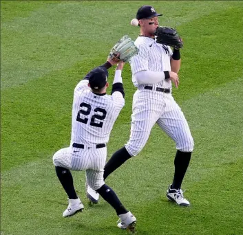  ?? Al Bello / Getty Images ?? Yankees Harrison Bader, left, and Aaron Judge are unable to catch a fly ball Saturday night in the second inning of ALCS Game 3 against the Houston Astros in New York. The Astros went on to score two runs in the inning.