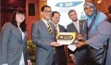  ?? PIC BY ABDULLAH YUSOF ?? Perak Menteri Besar Datuk Seri Ahmad Faizal Azumu (second from left) handing over the
Kad Perak Prihatin, a welfare card, to Aisyah Nur Fatihah at the launch of the card in Ipoh recently.