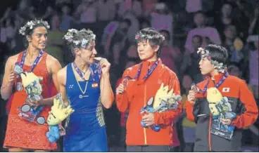  ?? AFP ?? ▪ Silver medallist P.V. Sindhu, champion Carolina Marin and thirdplace­d He Bingjiao of China and Akane Yamaguchi of Japan chat on the podium at the BWF World Championsh­ips in Nanjing, China on Sunday.