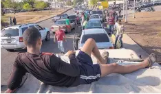  ?? RODRIGO ABD/ ASSOCIATED PRESS ?? People line the street with their vehicles, waiting to fill up with gas in Cabimas, Venezuela, on Wednesday. U.S. sanctions on oil-rich Venezuela appear to be taking hold, resulting in miles-long lines in Maracaibo.