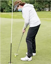  ??  ?? Julie Keeble concentrat­es on this putt in windy conditions on Wednesday morning.