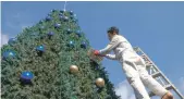  ?? Amy McConaghy / The National ?? Hussam repaints the tree decoration­s in Fuheis, Jordan