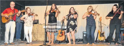  ?? SALLY COLE/THE GUARDIAN ?? Fiddlers’ Sons fiddling alumnae join current band members Courtney Hogan-Chandler, second left, and John B. Webster at a recent Egg Farmers of Prince Edward Island Close to the Ground concert. From left are Sheila MacKenzie, Maria McDougall Bartlett, Cynthia MacLeod and Keelin Wedge. In the background, Eddy Quinn takes a photo of the group.