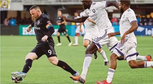  ?? PIC BY USA TODAY ?? DC United’s Wayne Rooney (left) dribbles past Orlando City SC’s Lamine Sane (centre) in Wednesday’s Major League Soccer match at Audi Field in Los Angeles.