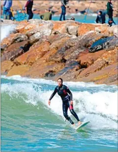  ?? FADEL SENNA/AFP ?? Meriem, a 29-year-old Moroccan engineer and surfer, surfs off the coast of Rabat.