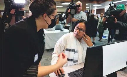  ?? MARC VASCONCELL­OS/USA TODAY NETWORK ?? Ella Azoulay of the Student Borrower Protection Center helps Giselle Morton of East Bridgewate­r, Massachuse­tts, with her student debt loan at Massasoit Community College in October.