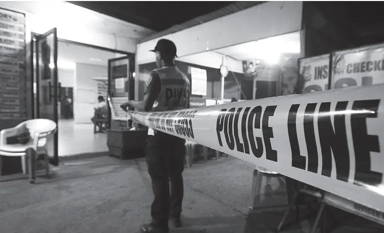  ??  ?? A MEMBER of the police auxiliary of San Pedro Police Station seals the scene following the death of police officer inside the San Pedro Police Station Tuesday evening. BING GONZALES