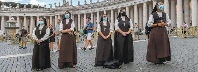  ?? TIZIANA FABI AGENCE FRANCE-PRESSE ?? Des soeurs assistaien­t à la prière de l’angélus dimanche sur la place Saint-Pierre. Le Saint-Siège avait indiqué le 7 juin qu’il n’y avait plus aucun cas de nouveau coronaviru­s dans la Cité-État.