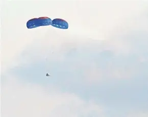  ?? TONY GUTIERREZ/AP ?? Blue Origin’s New Shepard capsule parachutes safely down to the launch area near Van Horn, Texas, Tuesday.