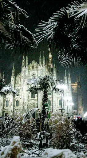  ??  ?? Il Duomo tra le palme imbiancate dalla prima nevicata del 2017 a Milano