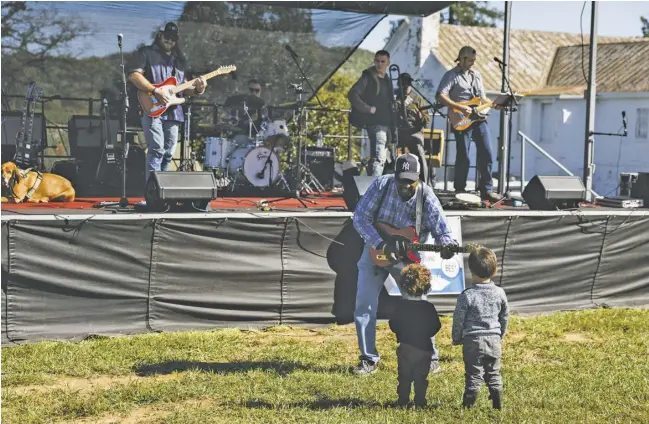  ?? PHOTOS BY LUKE CHRISTOPHE­R ?? Bobby “G” Glasker and the Heavies play for a couple of youngsters at the Headwaters Foundation Harvest Festival on Saturday.