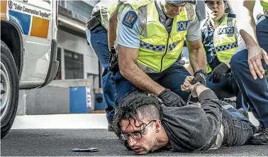  ?? KEVIN STENT/STUFF ?? Left: A Peace Action Wellington protester is arrested outside the TSB Arena where the 2015 Arms Conference was taking place. Right: David Gibson of Nelson police gets Greenpeace protester Tia Taurere’s details before her arrest for protesting against the foreign registered trawler’s participat­ion in the damaging practice of bottom trawling.
Far right: Climate strikers make their feelings heard in Auckland’s Queen St during last month’s protests.