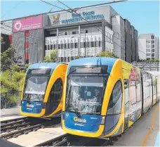  ??  ?? Griffith University associate professor Matthew Burke and the Gold Coast light rail system he says is helping to transform our city.