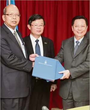  ??  ?? It’s a deal: Farizan (left) exchanging documents with Lim as Chow looks on after the MoA signing at Komtar.