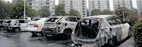  ??  ?? Burned-out cars sit in the shadow of high-rise apartment blocks after worst of the arson rampages hit the city of Gothenburg