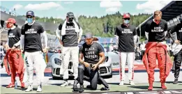  ??  ?? Left: Mercedes’ British driver Lewis Hamilton (centre) kneels ahead the Austrian Formula One Grand Prix race in Spielberg, Austria, on Sunday in solidarity with the “Black Lives Matter” movement. Right: Mercedes driver Valtteri Bottas of Finland poses with his trophy and a bottle of champagne after winning the Austrian GP. — AFP, AP