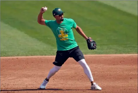  ?? JEFF CHIU
AP PHOTO/ ?? Oakland Athletics’ Marcus Semien throws during a baseball workout in Oakland, Calif., Monday.