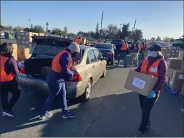  ?? DAILY DEMOCRAT ARCHIVES ?? Food Bank volunteers carried boxes of fresh vegetables and dry goods to people are food insecure at the Yolo County Fairground­s during a previous food distributi­on.