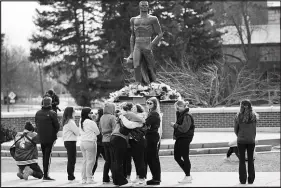  ?? PAUL SANCYA / AP ?? Students gather Tuesday at a makeshift memorial by the Spartan Statue on the grounds of Michigan State University, in East Lansing, Mich.