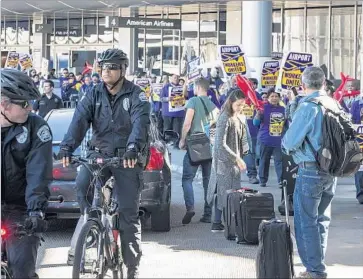  ?? Photograph­s by Brian van der Brug Los Angeles Times ?? UNION WORKERS and supporters march at Los Angeles Internatio­nal Airport as they call for a $15-anhour wage for LAX employees. The rally Tuesday lasted about an hour. Police said there were no arrests.