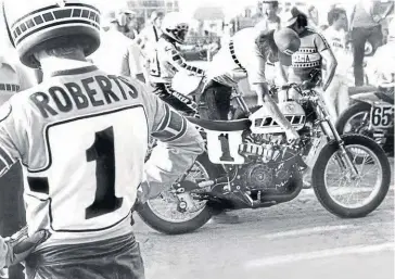  ??  ?? '"They don't pay me enough to ride that thing..." King' Kenny Robers looks on as his fiesty Yamaha TZ700 gets fettled ahead of a race.