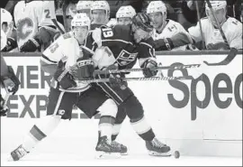  ?? Chris Carlson Associated Press ?? THE FLAMES’ Johnny Gaudreau, left, battles the Kings’ Alex Iafallo during Saturday’s game. The Kings allowed an early goal and lost their second in a row.