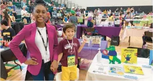  ?? CRISTÓBAL REYES/ORLANDO SENTINEL ?? Four-year-old author Sameer Jani, right, smiles next to Sumer Strawbree, 13, at his booth showcasing his “Chocovela” books at the Kid$ Bi$ Children’s Business Fair at Milwee Middle School in Longwood on Saturday. Strawbree, whose real name is Lauryn Jones, rose to online fame after introducin­g her coloring book,“Black, Brown & Beautiful,” at last year’s fair.