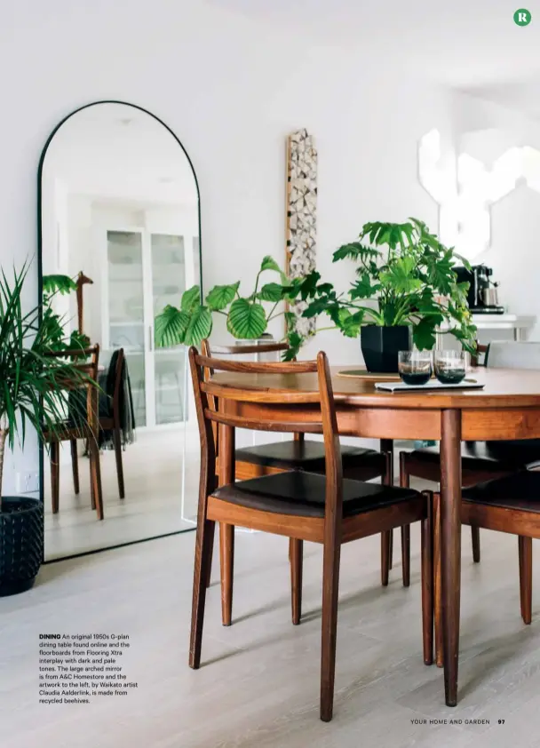  ??  ?? DINING An original 1950s G-plan dining table found online and the floorboard­s from Flooring Xtra interplay with dark and pale tones. The large arched mirror is from A&C Homestore and the artwork to the left, by Waikato artist Claudia Aalderlink, is made from recycled beehives.