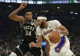  ?? PATRICK MCDERMOTT — GETTY IMAGES ?? The Lakers’ Anthony Davis (3) dribbles the ball against the Bucks’ Giannis Antetokoun­mpo (34) during the first half of Friday’s game at Fiserv Forum in Milwaukee.