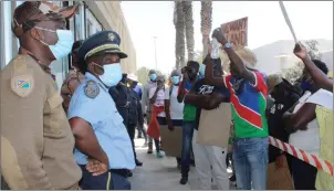  ?? Photo: Eveline de Klerk ?? Accountabi­lity… Protesters under the watchful eyes of the police in front of the Walvis Bay head offices.