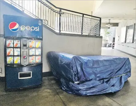  ?? Christophe­r Knight Los Angeles Times ?? THE KEY COMPONENT of “The Road to Hollywood” installati­on has been deposited next to a soda machine and wrapped in a tarp.