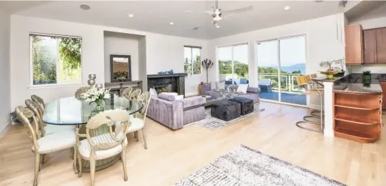  ?? PHOTOS BY MATT MCCOURTNEY / MCCOURTNEY PHOTOGRAPH­ICS ?? Above: Hardwood flooring lines a great room that opens to a view deck. Below: The patio features a glass railing and sparkling pool.