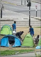  ??  ?? Les migrants dorment dans des tentes près de la ligne 1 du tram.