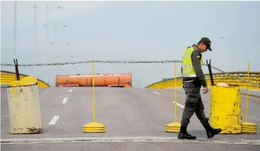  ?? AFP ?? Policía colombiana se prepara para la llegada de Guaidó en el puente “Tienditas”.