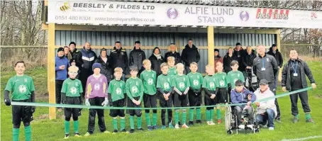 ??  ?? Alfie and Mark Lund cut the ribbon on the new stand with Burscough Dynamo U11s and managers Russell Evans and James Bevan