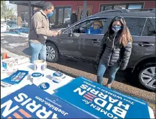  ??  ?? Congressma­n Joe Neguse gives a thumbs-up to Sara King as she drives through the Democratic Party headquarte­rs in Fort Collins to get campaign signs Tuesday.