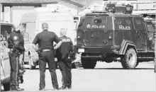  ?? LARRY MACDOUGAL THE CANADIAN PRESS ?? Calgary police and a tactical team vehicle at the shooting scene of a police officer in Calgary, Alta., on Tuesday.