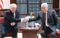  ?? AFP ?? BETHLEHEM: US President Donald Trump shakes hands with Palestinia­n leader Mahmoud Abbas during a meeting at the presidenti­al palace in this West Bank city yesterday.—