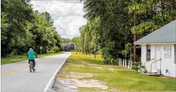  ?? ?? Carnell Mills rides his bicycle along Groover Hill Road in Ellabell. Bicycle and hiking paths, as well as other recreation­al amenities, are in the works. A shared-use path in Ellabell is one proposal.