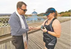  ?? STAFF PHOTO BY DAN HENRY ?? The Rev. Brandon Gilvin gives a blessing Tuesday to Angie Nunley who paused her 4-mile run to pray. Gilvin and other Chattanoog­a clergy from various religions offered prayers and bottles of water to passersby in their attempt to bring peace to a...