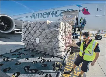  ?? Brian van der Brug Los Angeles Times ?? ADDING cargo-only f lights several times a week isn’t enough to make up for the loss of passengers. Above, American Airlines crew chief Edgar Segura pulls freight from a flight from Beijing at LAX in 2018.