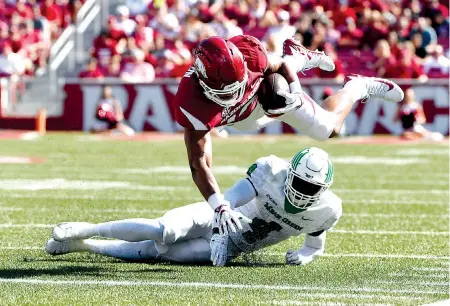  ?? Associated Press ?? ■ NORTH TEXAS 44, ARKANSAS 17. Arkansas tight end Jeremy Patton is tackled by North Texas defender Khairi Muhammad on Saturday in the first half in Fayettevil­le, Ark.