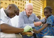  ?? COURTESY OF THE CARTER CENTER ?? Ex-President Jimmy Carter consoles a young patient having a Guinea worm removed from her body in Savelugu, Ghana, in 2007.