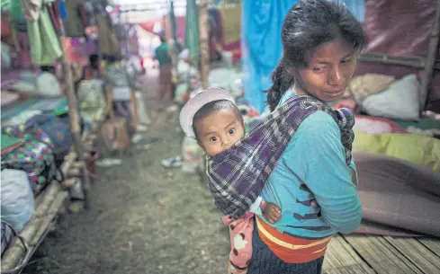  ?? AFP ?? An internally displaced woman and a child take temporary shelter in Danai, Kachin state, Myanmar on May 11. Renewed fighting in recent weeks in Kachin has added to the government’s woes.