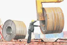  ??  ?? A worker using a crane to lift a roll of steel at a shipyard in Nantong in China’s eastern Jiangsu province. Chinese state media yesterday praised a significan­t dialling back of trade tension with the United States, saying China had stood its ground...