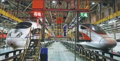  ?? ZHU XINGXIN / CHINA DAILY ?? A Fuxing (rejuvenati­on) bullet train (right) and a Hexie (harmony) bullet train undergo maintenanc­e at a depot late at night in Beijing earlier this month.