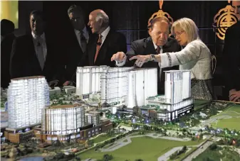  ?? Kin Cheung / Associated Press 2012 ?? Las Vegas hotel and casino magnate Sheldon Adelson and his wife, Miriam Ochsorn, point out features of a model of a resort they were building in China’s Macau region in 2012.