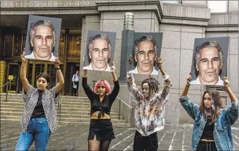  ?? Stephanie Keith Getty Images ?? PROTESTERS in New York hold signs of Jeffrey Epstein when he was charged with sex traffickin­g.