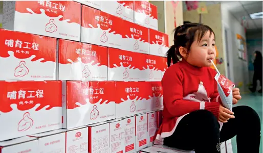  ??  ?? à Urumqi (région autonome ouïgoure du Xinjiang), la petite Li Xinyao, 4 ans, boit du lais frais fourni gratuiteme­nt par l’entreprise Terun.
